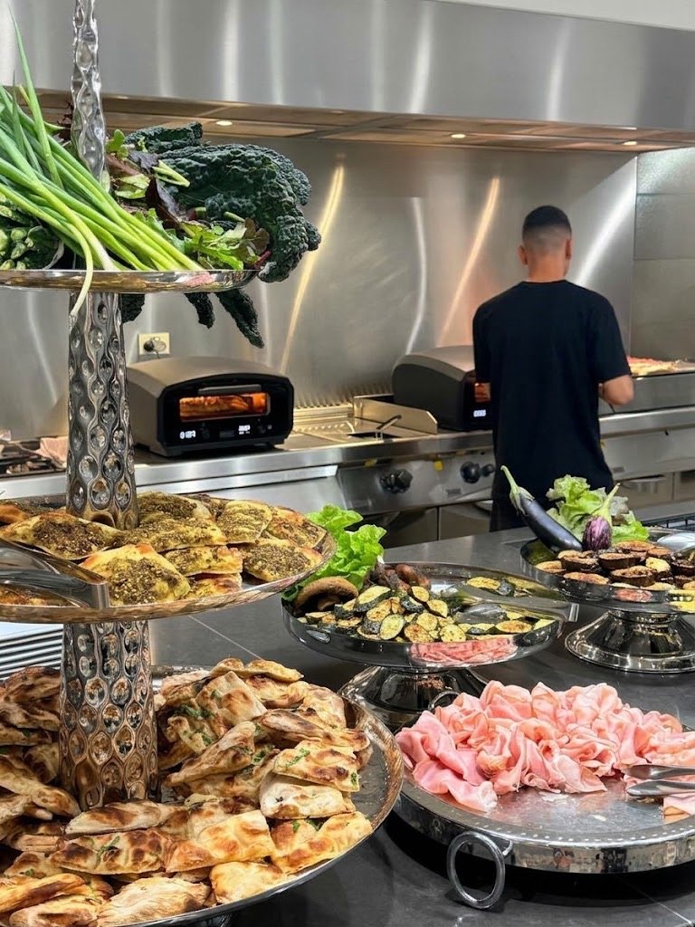 Silver stands of flatbreads and cold cuts beside the oven